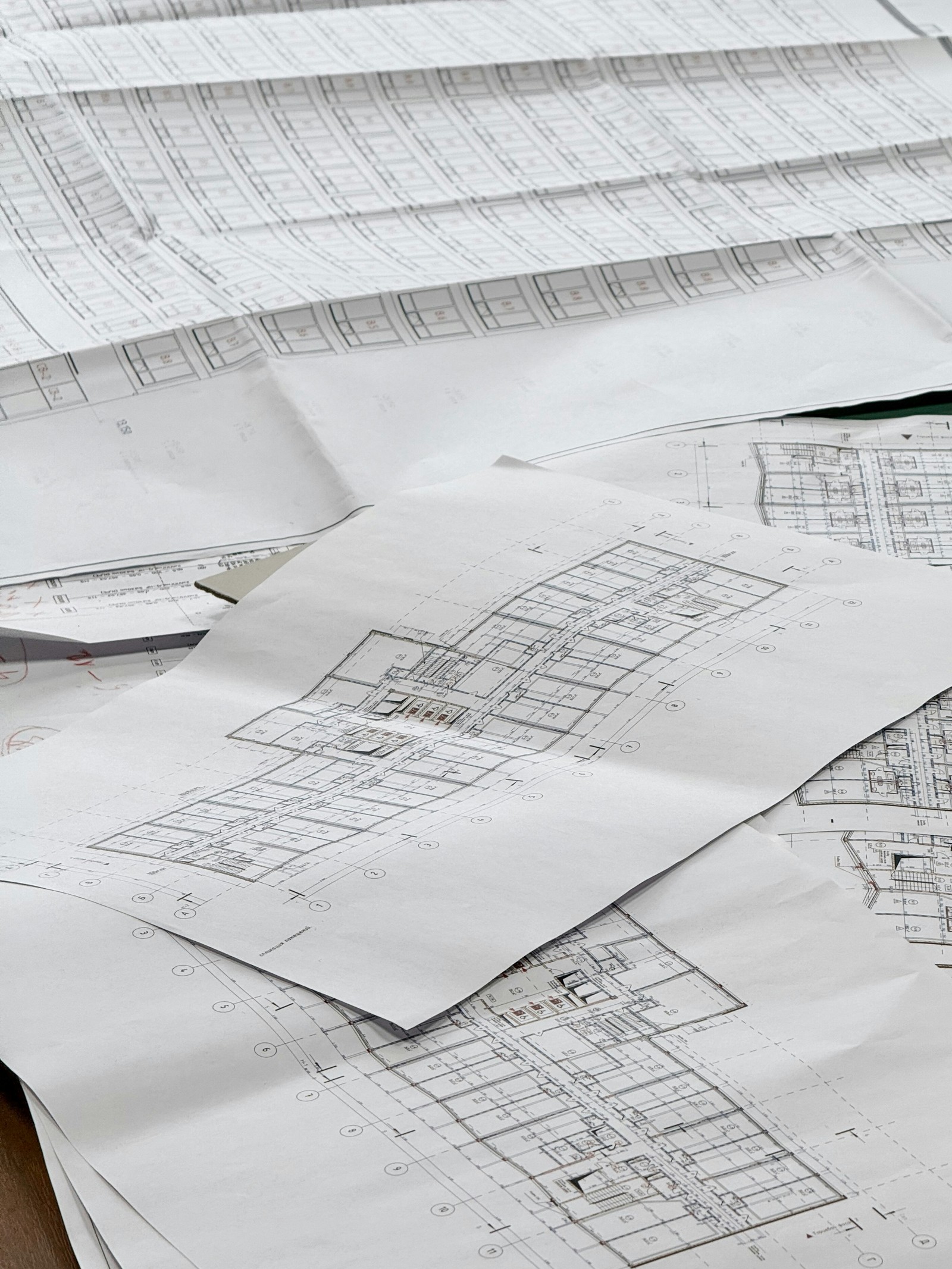 Reviewing blueprints together on site at a framed home
