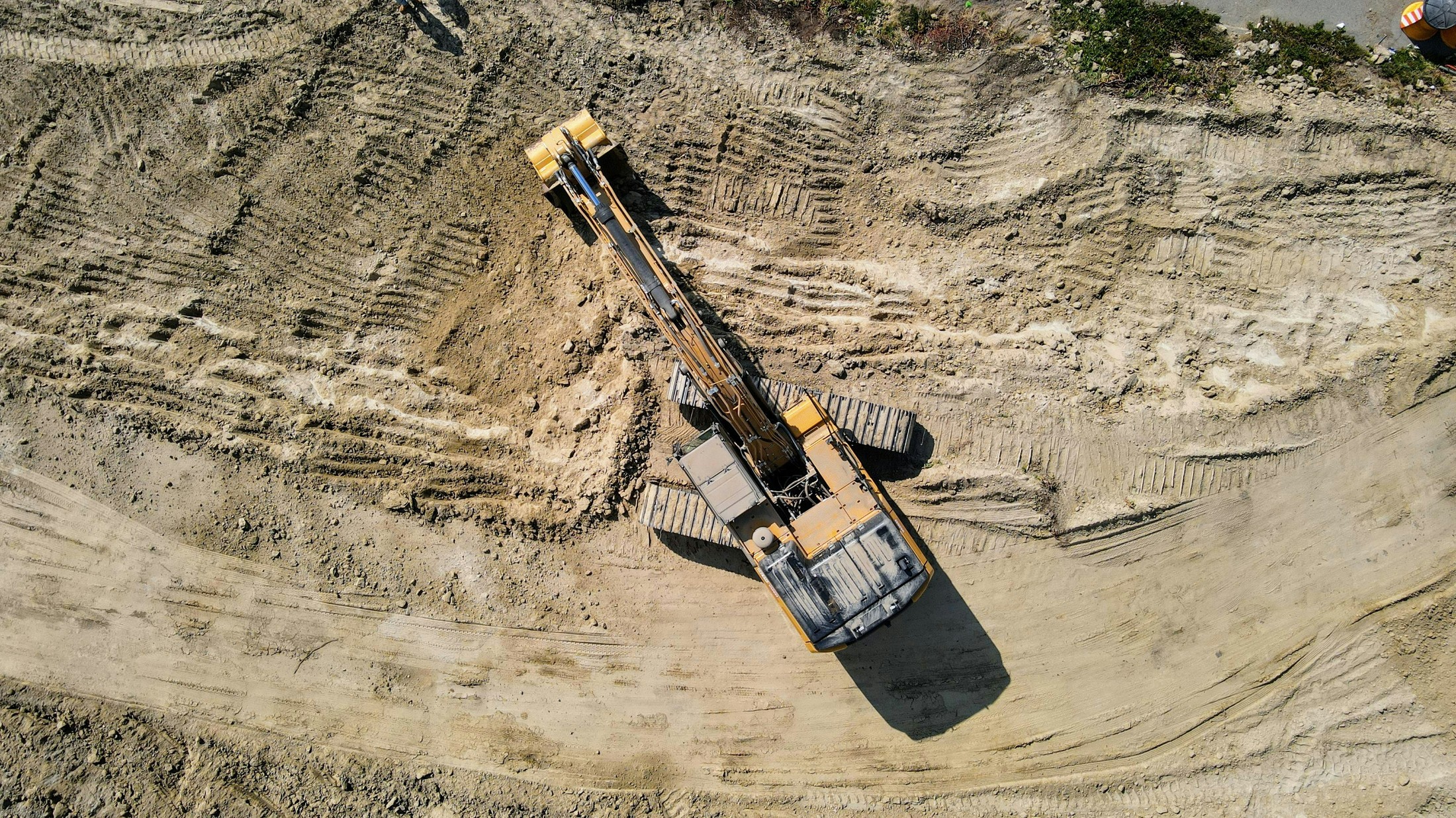 Skid-steer loader grading a site and cutting a utility trench