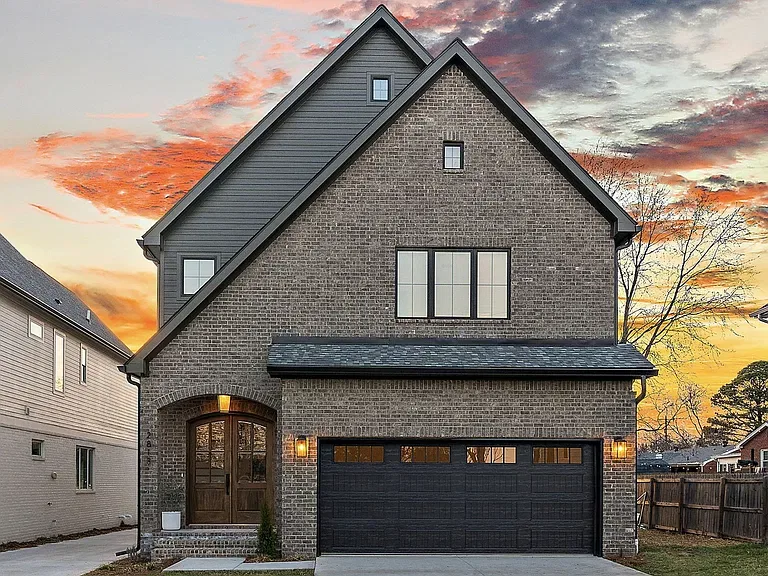 Brick front elevation with arched wood entry and two-car garage