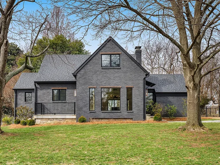 Dark painted-brick front elevation with steep center gable